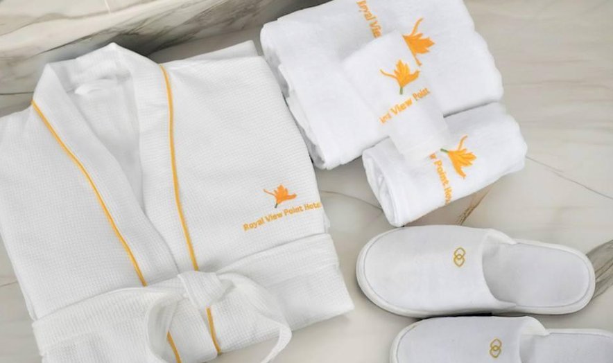 Embroidered robe, towels and slippers laid out together